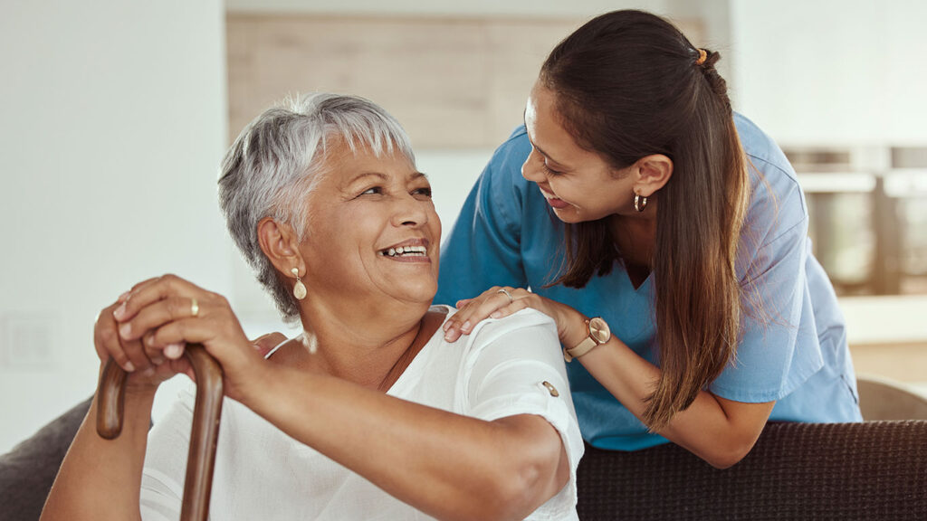 older woman smiling at in-home caregiver